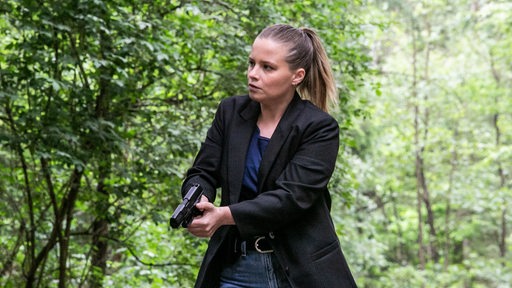 Liv Moormann (Jasna Fritzi Bauer) läuft mit einer Waffe durch den Wald.